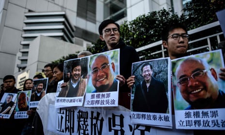 Hong Kong pro-democracy activist Avery Ng (C) holds a poster of jailed Chinese activist Wu Gan, known by the online pseudonym ‘Super Vulgar Butcher’.