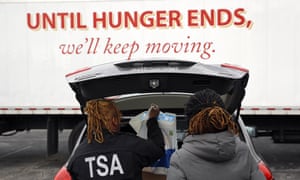TSA officers Princess Yang, left, and Erica Gibbs charge food in a car after visiting the Baltimore food pantry.