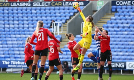 Manchester United goalkeeper Mary Earps punches clear to thwart a Reading attack.