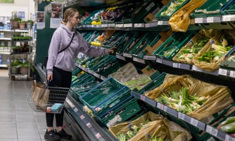 A customer seen choosing  vegetables in the supermarket. 