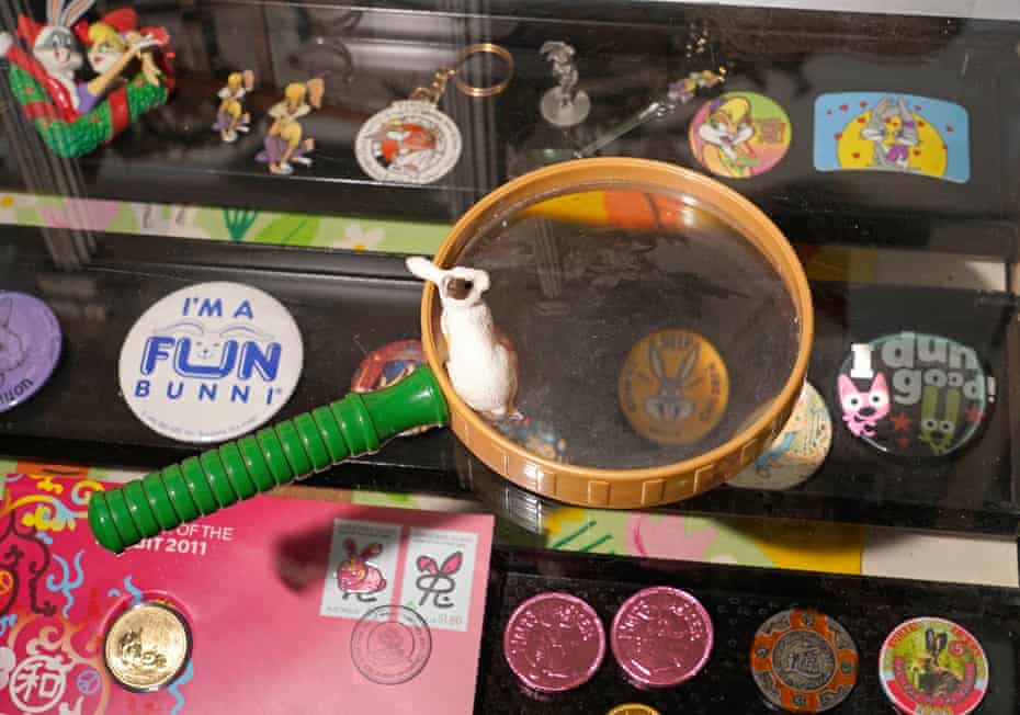 A display case containing the museum’s smallest items, including pins, coins and keychains, with a magnifying glass on top.