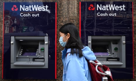 A pedestrian walks past a NatWest bank in London