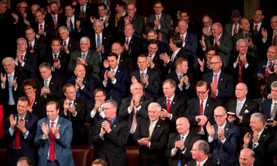 Republican members of Congress listen as Trump speaks.