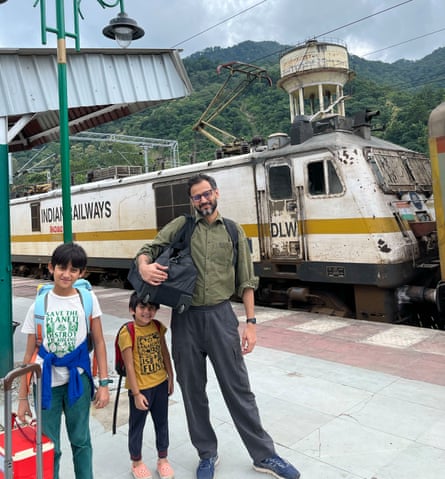 Rahul Bhattacharya standing next to two children on a station platform