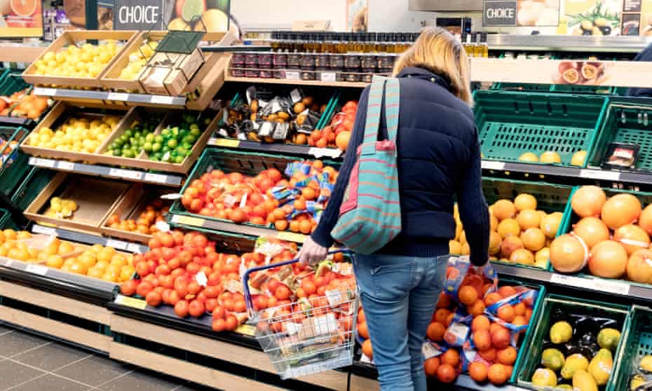a woman shops on the fruit and vegetable aisle
