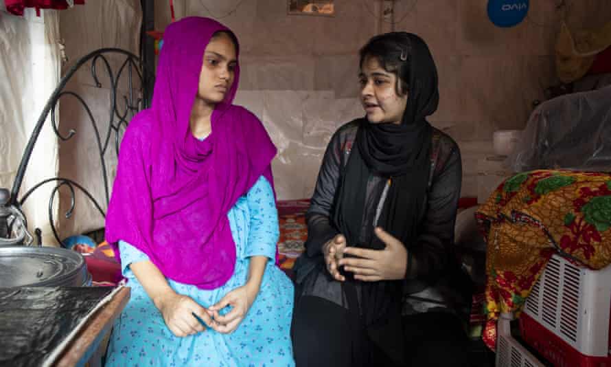 Humayara Jeba, right, and Rita Akhter, sitting on bed.