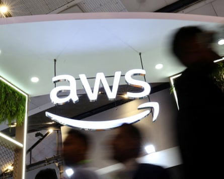 people walk by sign that says ‘aws’ in white