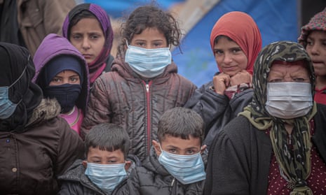 Children and an elderly woman wear masks as a preventive measure against the coronavirus in Idlib.
