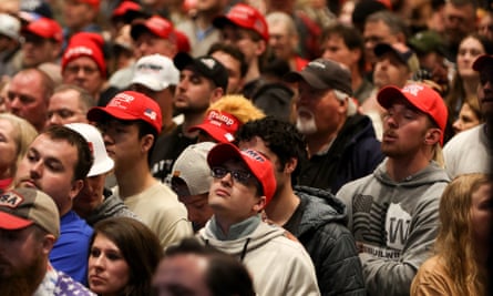 Crowds of people, many wearing red hats