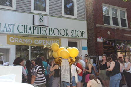 crowd outside bookshop with balloons and sign that says ‘grand opening’