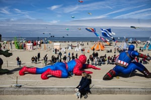 Large inflatable superheroes depicting Spider-Man and Captain America line the back of a beach while people watch kite-flying in Berck-sur-Mer, France

A woman watches people flying kites at the beach, during the 37th International Kite Festival