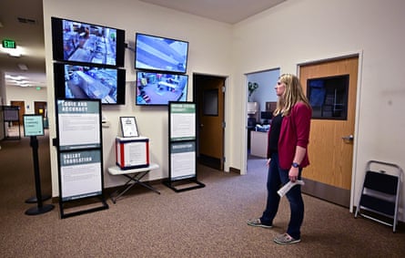 Woman watches four big screens on a wall.