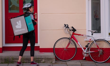 A young self-employed woman girl with her bicycle working for Deliveroo