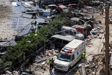 An ambulance vehicle parked next to debris from an airstrike.