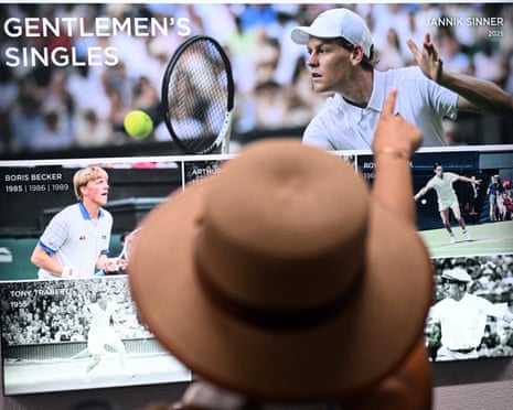 A person in a hat points at a display screen showing past Wimbledon champions in Gentlemen's Singles
