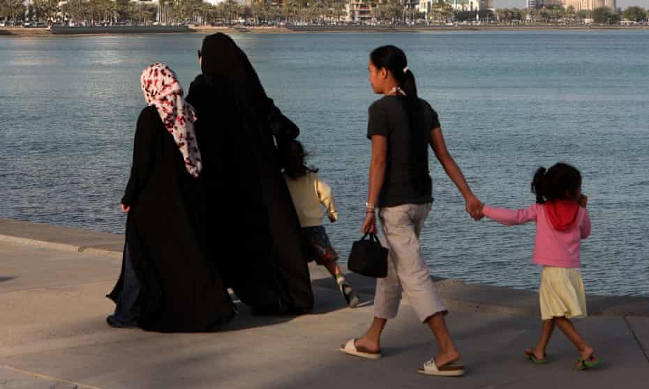 A housemaid accompanies two Qatari women with their children in Doha’s Corniche