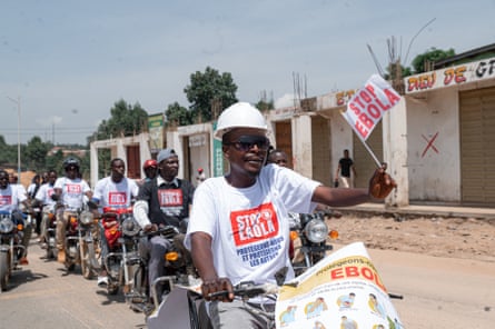 Motorcycle taxi drivers carrying banners to promote Ebola virus disease prevention in Bunia