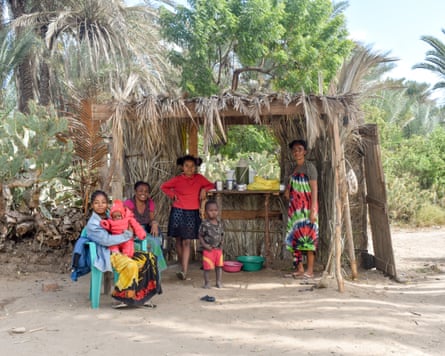Several people standing by a coffee stall made from wood and reeds