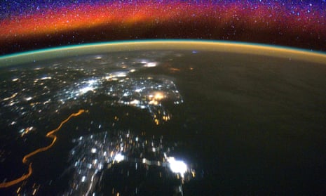 Bright swaths of red in the upper atmosphere, known as airglow, seen from the International Space Station.