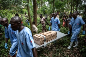 Red Cross workers bury an 11-month-old girl who died in the town of Rutshuru during the Ebola outbreak, February 2020.