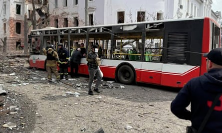 Rescuers examine the wreckage of a bus