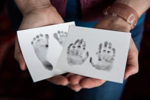 Kateholds her baby Laurel’s foot and hand prints that were made by nurses at the clinic.