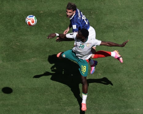 France's Theo Hernandez (top) and Senegal's Ismaila Sarr jump for the ball.