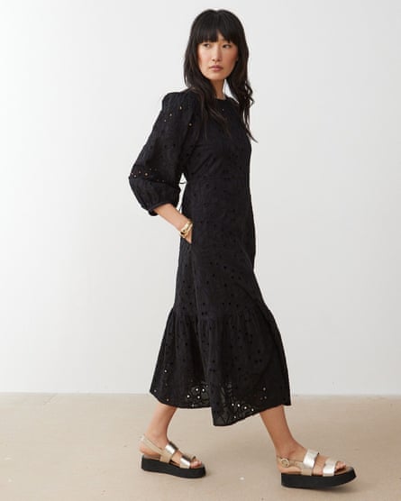 Model wearing tiered black broderie anglaise maxidress