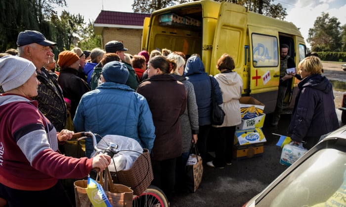 People receive humanitarian aid in Prykolotne village, Kharkiv, Ukraine on Sunday.