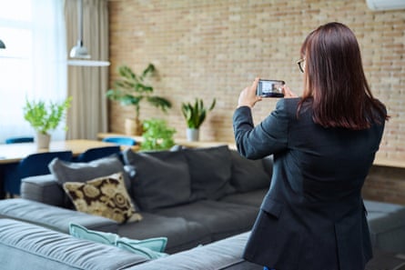 A woman taking a photo of the interior of a house