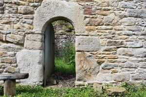 Classic bastle doorway of megalithic stone cut into a semicircular arch.