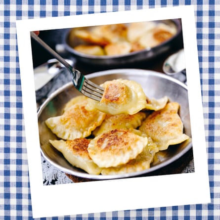 Eating traditional Polish dumplings, Pierogi, from a dish with a fork.