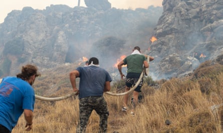 Firefighter teams try to extinguish a wildfire in Rhodes.