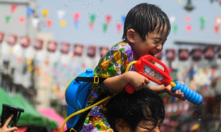 A child sprays a water gun during a water fight to celebrate Thai new year.