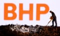 A small toy figure and mineral imitation are seen in front of the BHP logo