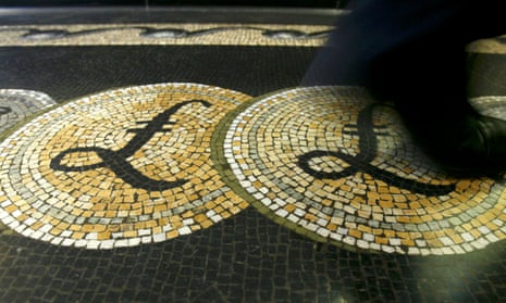 shows an employee walking over a mosaic depicting pound sterling symbols on the floor of the front hall of the Bank of England in London.