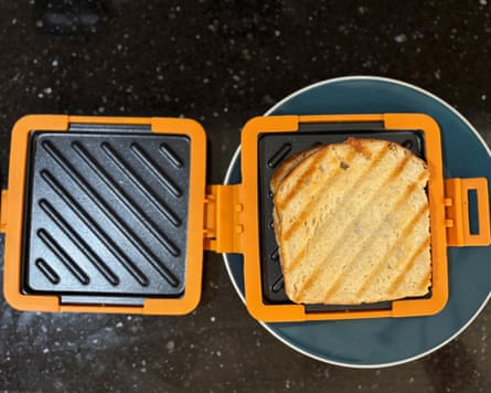 A Morphy Richards Mico toastie maker open with a golden brown sandwich on the right hand side.