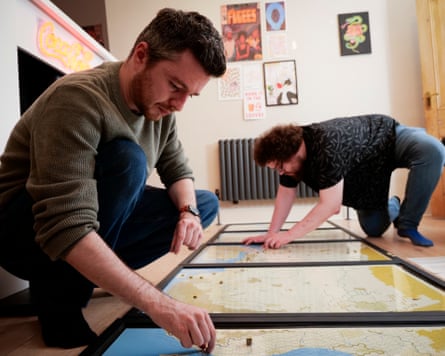 Taeger and Purcell sitting on the floor over a huge game board of the north African coast