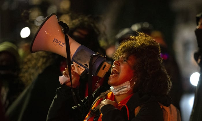 A protester with a loudhailer on a march through the streets of Seattle in remembrance of Breonna Taylor.
