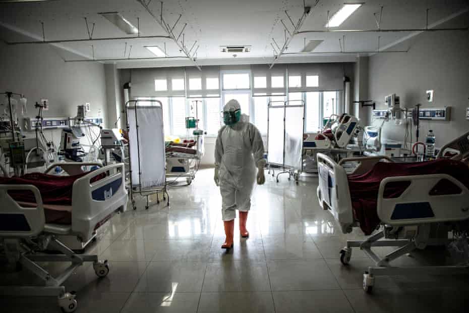 Seorang paramedis memeriksa pasien dengan virus corona Kovit-19 di bangsal ICU sebuah rumah sakit di Pokhara.