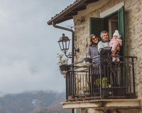 Cinzia Trabucco and Paolo Bussi stand on their balcony with their baby, Lara Bussi Trabucco.