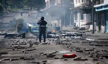 A French police officer at a makeshift roadblock set up by pro-independence supporters in the Vallée du Tir district of Nouméa, New Caledonia