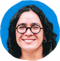 woman in glasses smiling with blue background