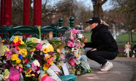 A woman leaves flowers at a memorial site for 33-year-old Sarah Everard in London Friday.
