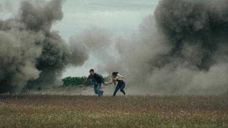 Couple running between plumes of smoke in a field.