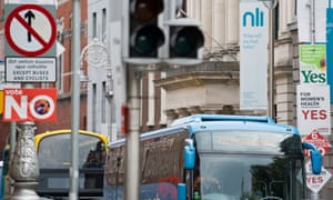 Buses pass signposts covered in placards from the “Yes” and “No” campaigns in Dublin on Thursday