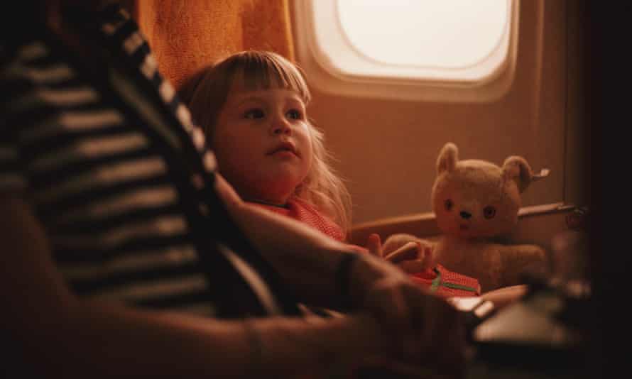 A child travels on a plane with her teddy