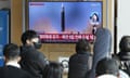 People watch a news reports on North Korea’s missile launch on a TV at the Seoul Railway Station.