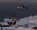Houses in snow next to sea with military vessel on it