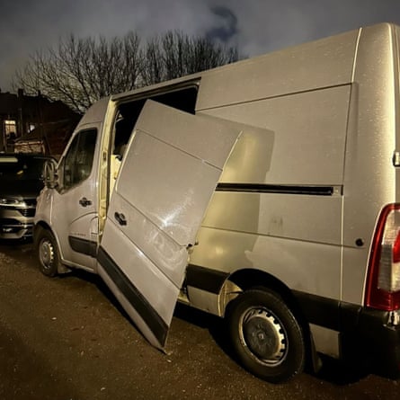 A white van with the sliding door hanging half off